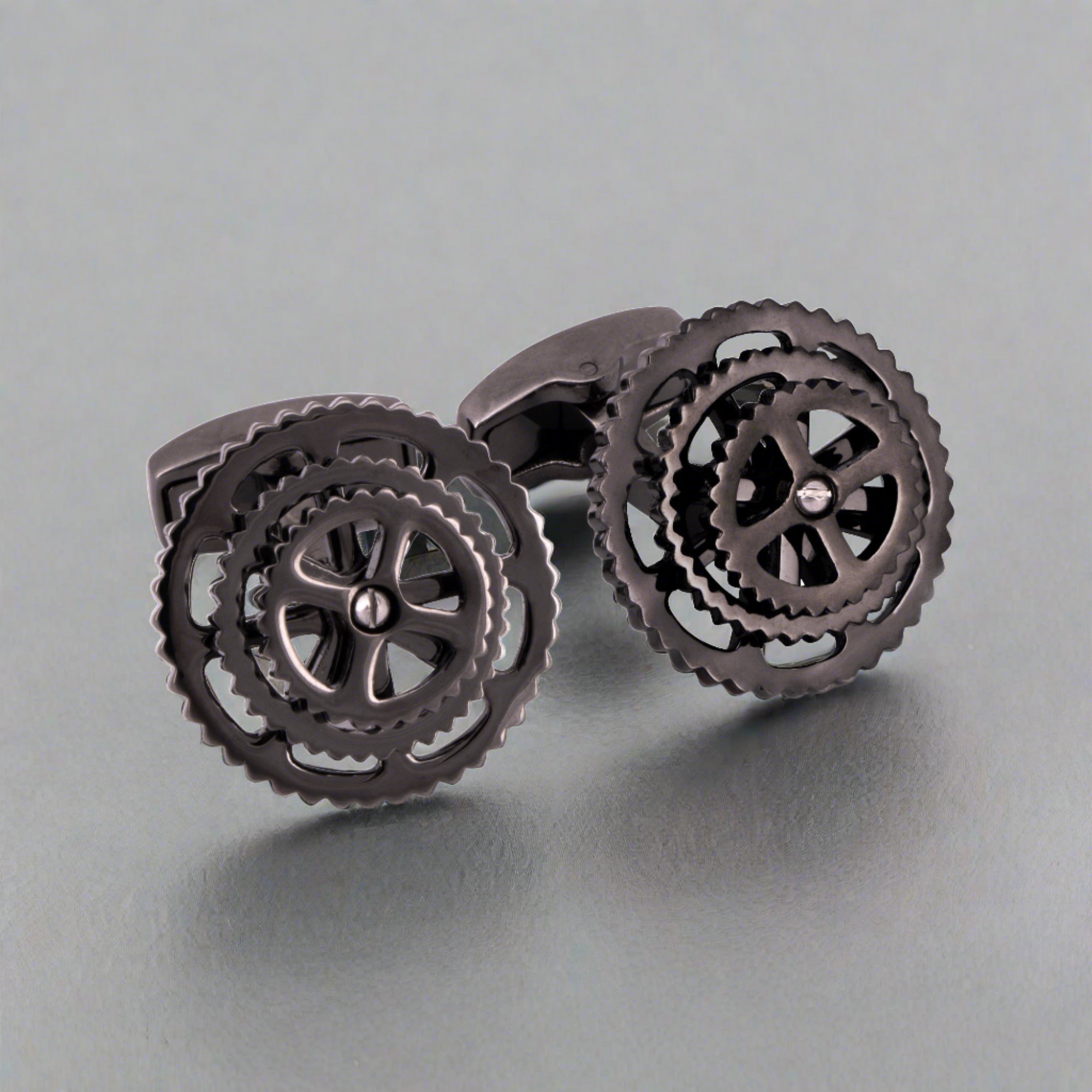 A pair of gunmetal bike gear cufflinks with a whale-back toggle closure.