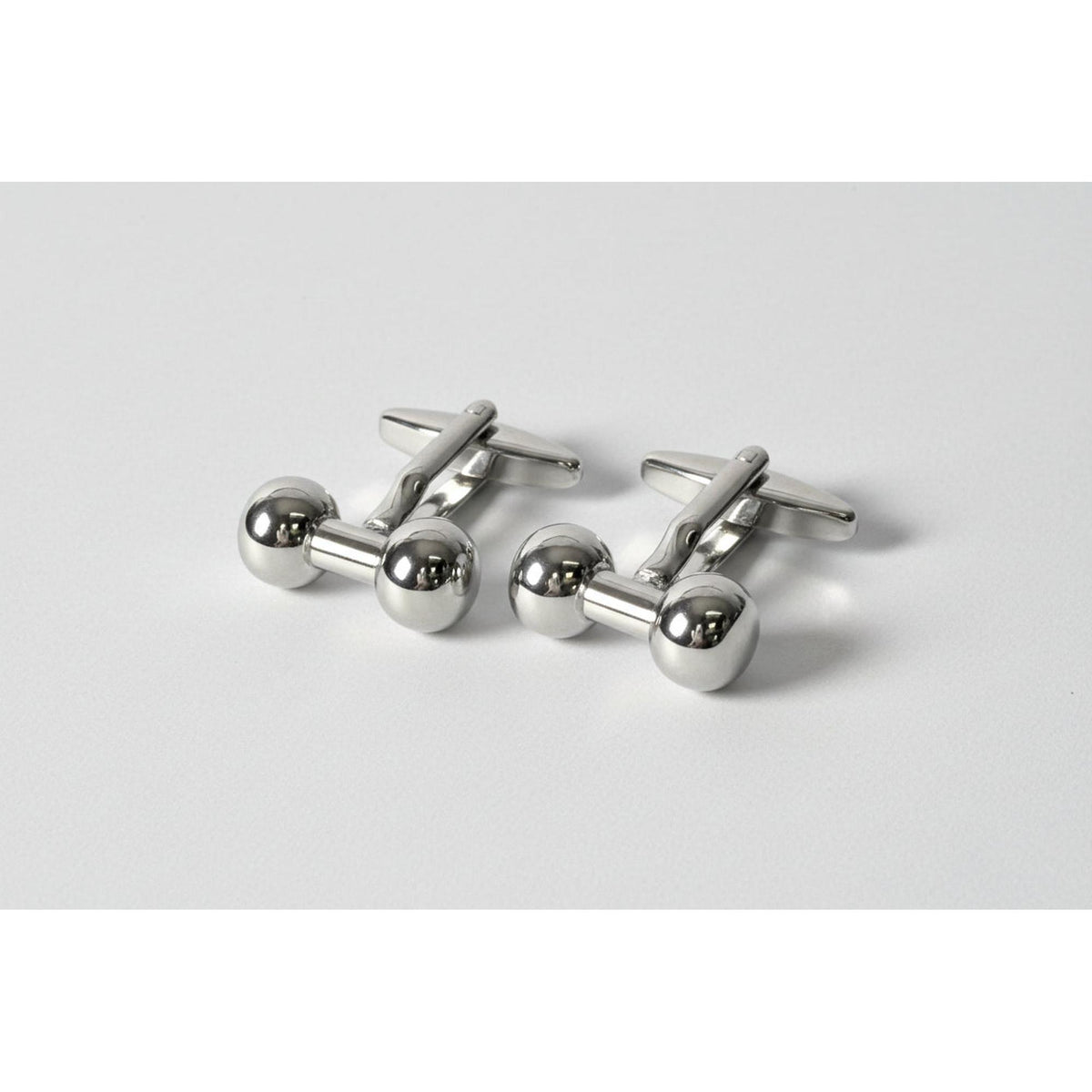 Silver dumbbell-shaped cufflinks on a white background