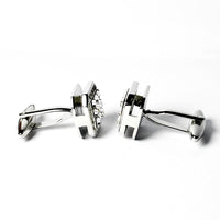Pair of silver cufflinks with a clear gemstone on a white background