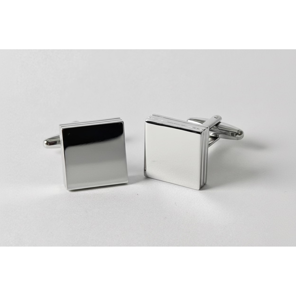 Pair of silver square cufflinks on a light gray background