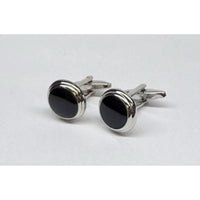 Pair of silver cufflinks with black stones on a light gray background